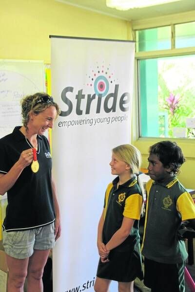 STRIDING FOR GOLD: Olympic swimmer Lara Davenport shows B'Llana Luck and Griffin Marshall from Healy State School the gold medal she won at the 2008 Beijing Games as part of the Australian 4 x 200 metre women's freestyle relay team. Davenport is in Mount Isa with Matildas World Cup player Lauren Colthorpe as part of the Stride Foundation's Sport for Life program. Both athletes spoke t