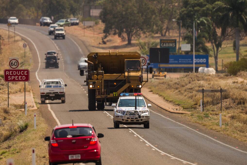 POLICE ESCORT: Dump trucks, water trucks and other mining equipment was used to fight bushfires, which came dangerously close to the city.