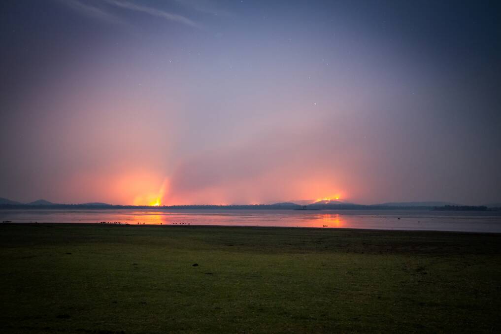 EERIE: Bushfires near Lake Moondarra create a glow on the horizon and reflections in the water.